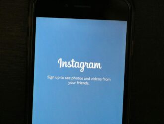 Close-up of a smartphone displaying the Instagram app welcome screen, inviting users to sign up.