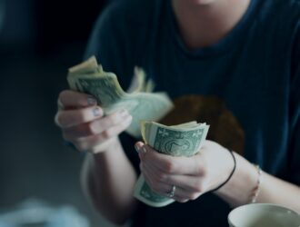 focus photography of person counting dollar banknotes
